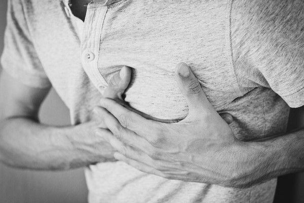 Mann hält sich die schmerzende Brust wie bei plötzlichem Herztod