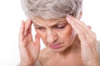 Frau hält sich den Kopf bei Wetter bedingten Kopfschmerzen