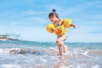Kind spielt am Strand im Meer