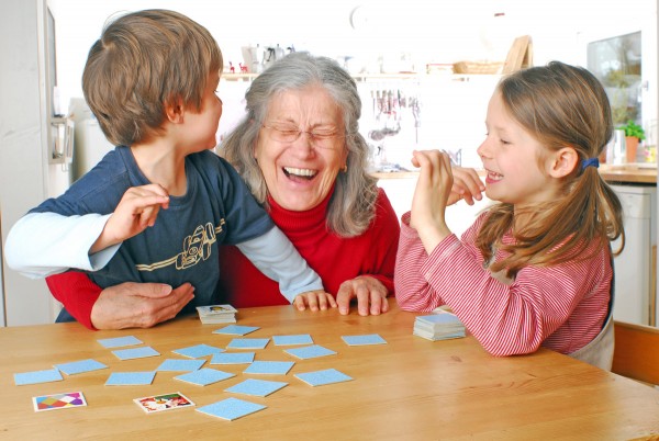 Ältere Frau nutzt Memory mit ihren Enkeln als Gedächtnistraining