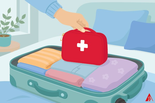 Eine rote Medizintasche mit Medikamenten für den Urlaub wird gerade im Reiskoffer verstaut.
