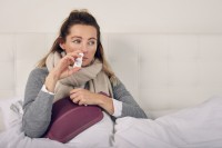 Frau mit Nasennebenhöhlenentzündung nutzt Nasenspray zur Behandlung