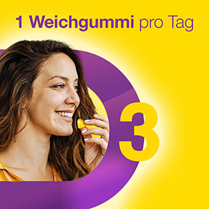 Frau lächelt und nimmt einen Vigantolvit Weichgummi ein, um den täglichen Bedarf an Vitamin D3 zu decken.