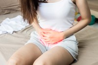 Frau hält sich wegen einer Blasenentzündung schmerzhaft den Unterleib